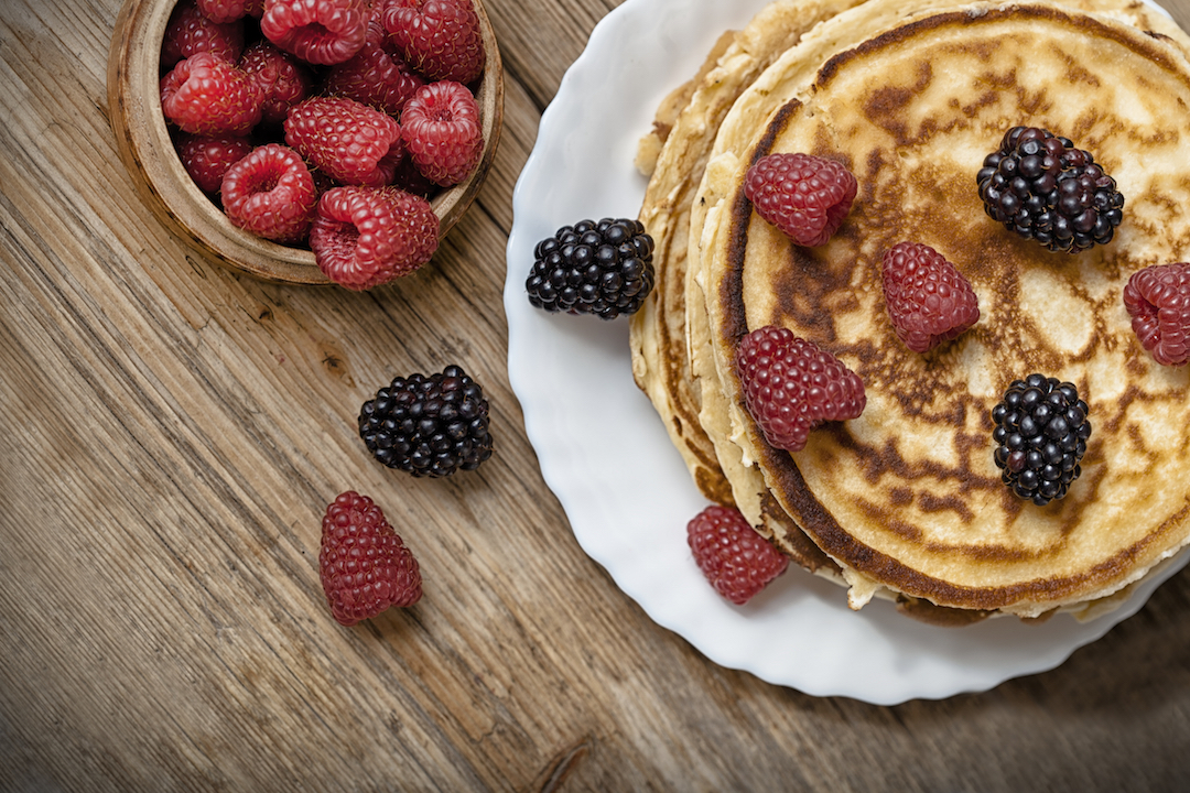 Delicious pancakes with berries on the wooden table