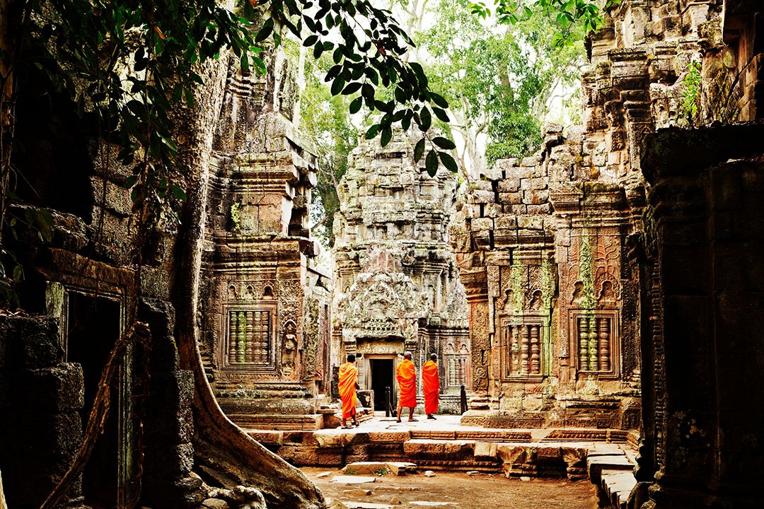 Monks wandering through temple ruins of Ta Prohm, Angkor, Cambodia. Photo by Mark Read.