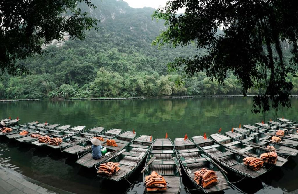 rows of boats sit docked on a river in Vietnam 