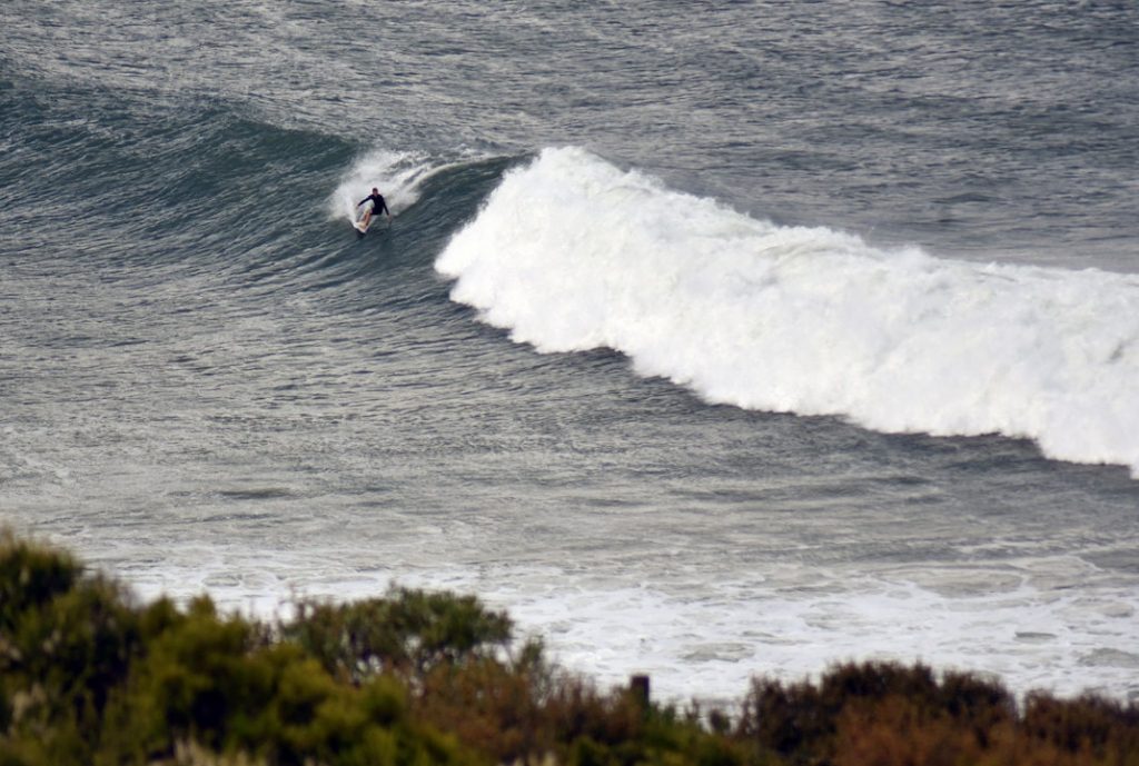 Surfer tackles a wave at the iconic Bells Beach, Victoria