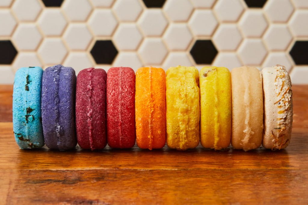 multicoloured shampoo bars lined up in front of a black and white tile background