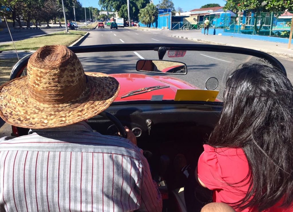 Driving around in a red vintage car in Havana with a local