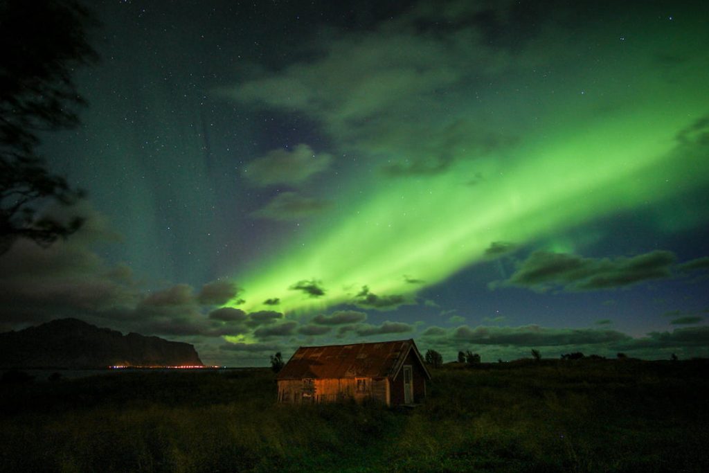 Aurora Borealis light up the skies above a cabin in Vestersand, Nordland, Norway, one of the best winter 2018 European destinations.