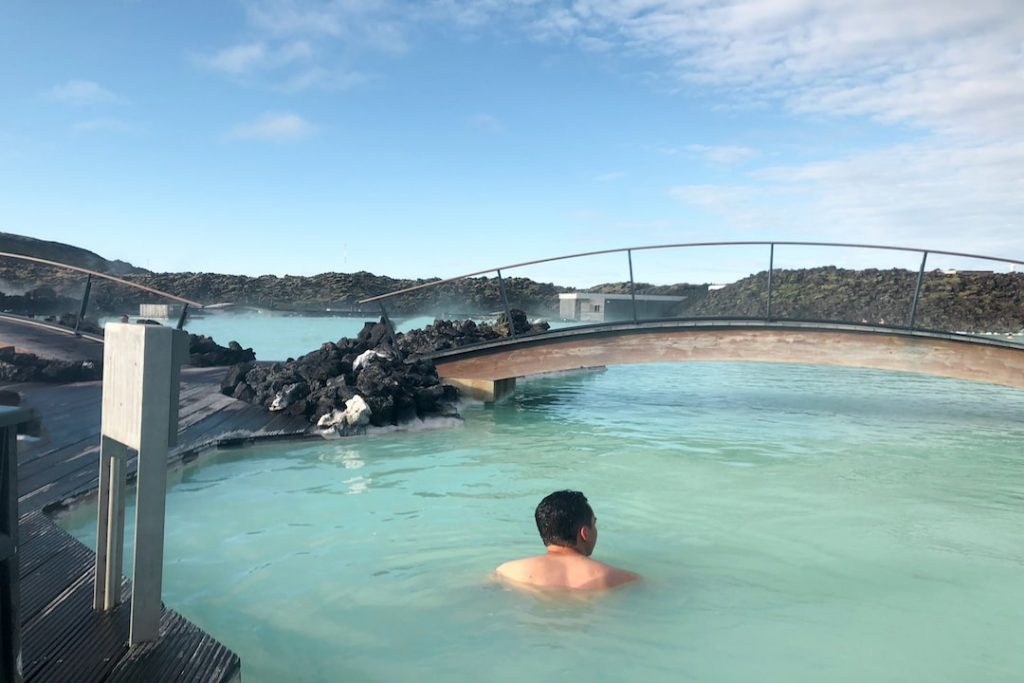 A man faces away from the camera while dipping in Iceland's Blue Lagoon