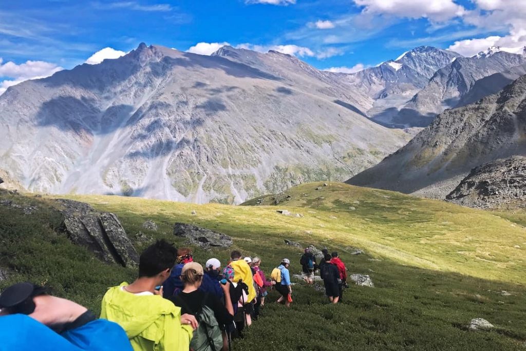 A line of people walking through a mountain range