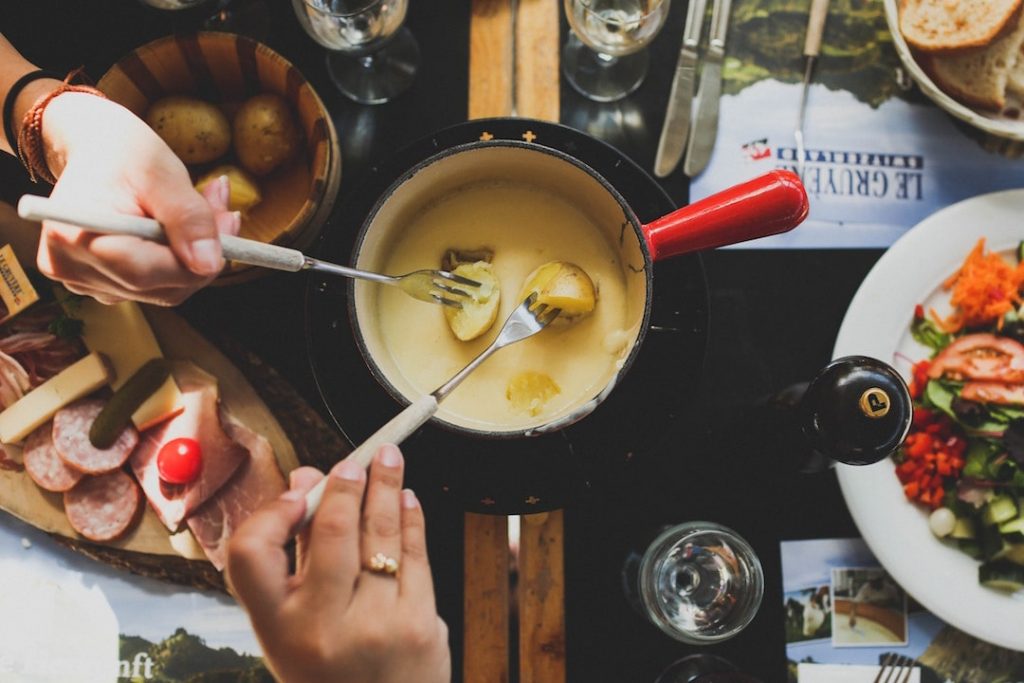 people dipping food into fondue