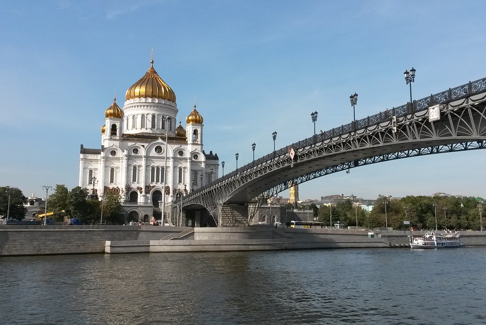 view of a golden domed white cathedral from the river