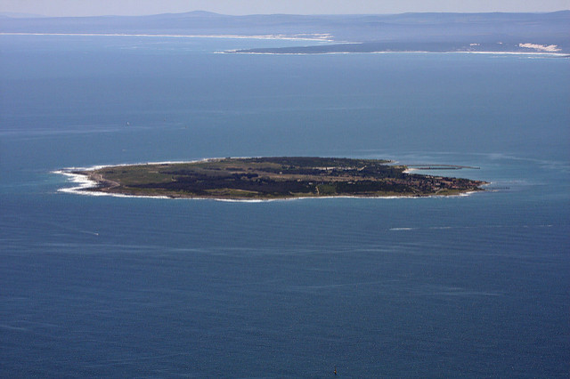 View of Robben Island from a far surrounded by the sea