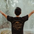 A man opening his arms in front of a waterfall in Bangkok, Thailand