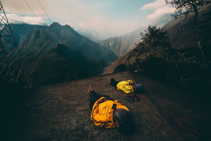 Two people in yellow jackets laying down on the Ica Trail