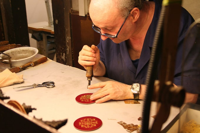 A leatherworker carves patches in Florence