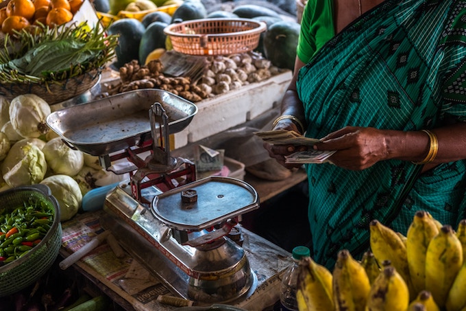 A woman holding money in a market in India