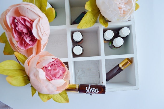 Vials of skincare products in a box surrounded by pink peonies