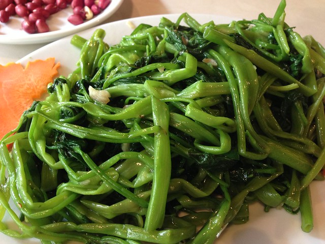 a plate of shredded bright greens with seasoning 