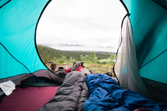 Sleeping bags inside a tent overlooking the woods in Alaska