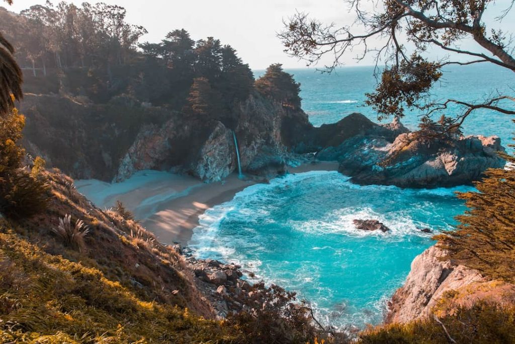 Hidden cove with beach and waterfall in California