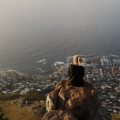 A woman sitting on Lion's Head looking over South Africa