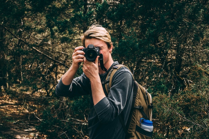 A man with a canon camera held up to his face