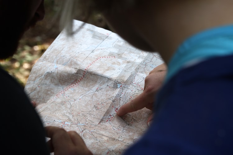 two people at a map and pointing at something on it