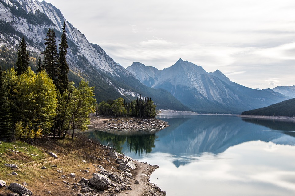 a still lake with mountains reflecting in it