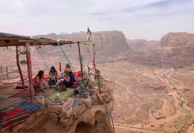 people sitting together on a cliff in Jordan