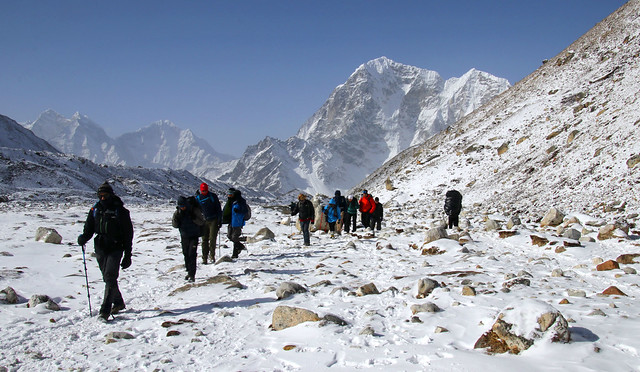 A tour group makes its way through icy alpine plateaus