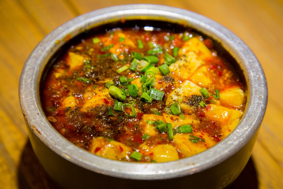 cubes of white tofu in a red paste in a dish