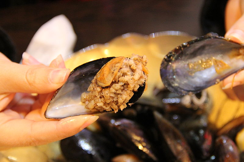 Person holding midye dolma, stuffed mussels, in Istanbul, Turkey