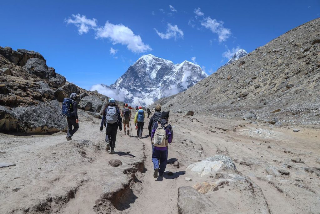 a group of people walking through the mountains