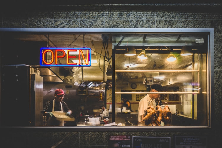 shop window of a chinese restaurant with cooked ducks hanging in it