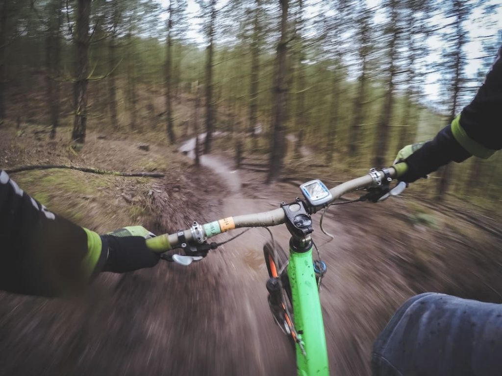 View of trail from behind handlebars on a mountain bike