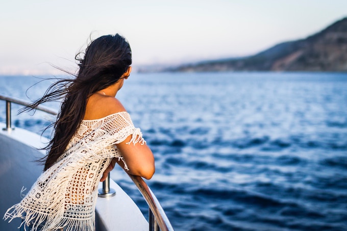 A woman leaning over a railing on a cruise boat in Cyprus