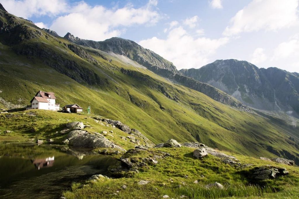 Mountain lodge in a valley beside mountains