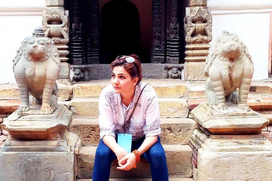 a woman sitting on stone steps outside a building