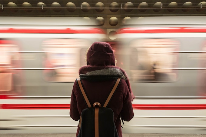 A woman standing in front of a train