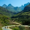 Two people walking on a path amongst green hills