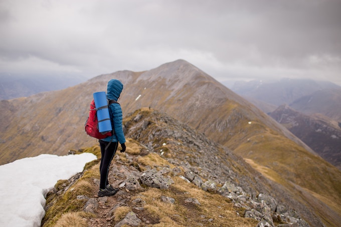 A person in a blue jacket hiking in the Peak District, UK