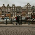 A woman walking beside a canal in Amsterdam