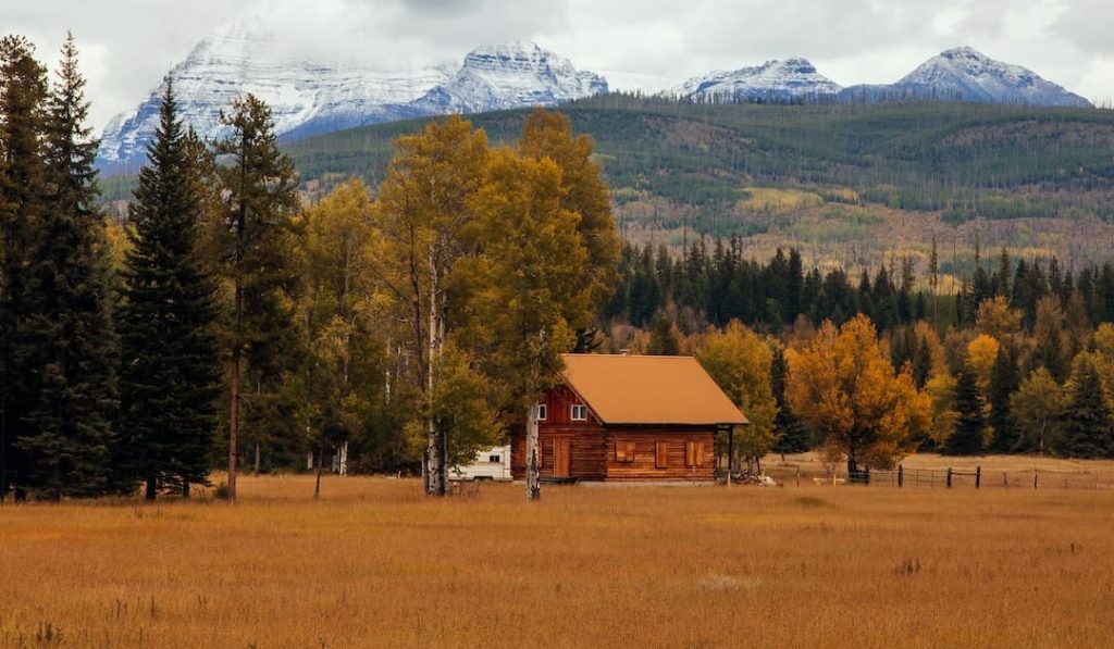 A wooden hut beside fall foliage in Glacier National Park, Montana