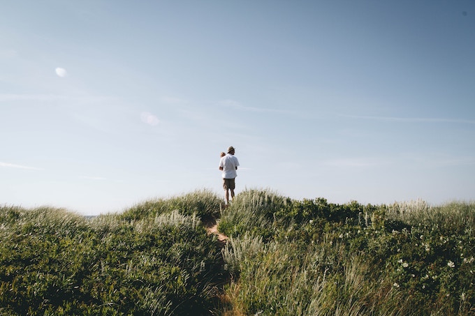 A man holding a baby while standing on a hill in Prince Edward Island, Canada