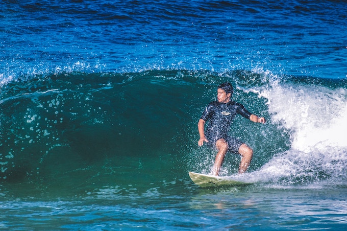 A man surfing on a small wave in Rio de Janeiro, Brazil