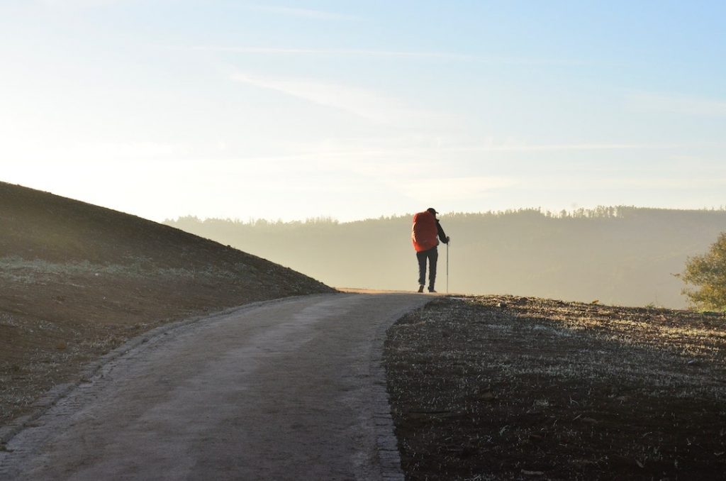 Man with backpack walking along the Santiago de Camino, Spain