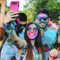 a group of people with colour on their faces taking a picture of themselves