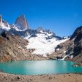 A turquoise lake with the peaks of Mount Fitz Roy behind in Patagonia