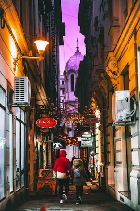 two person walking in a colourful alleyway