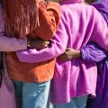 a group of women with their arms around one another