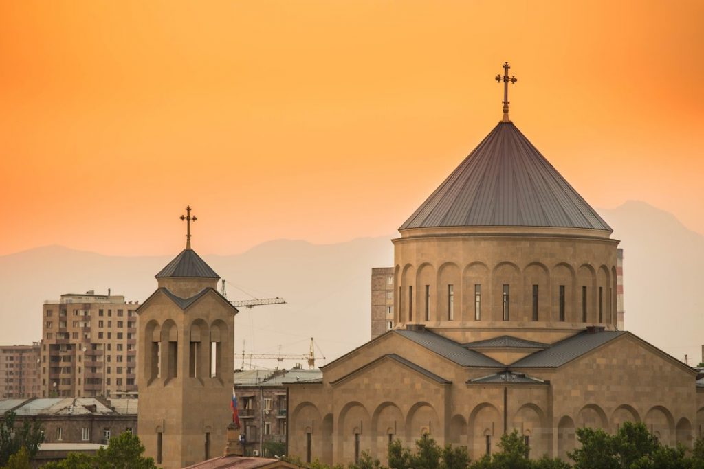 A monastery in Armenia with an orange sky in the background