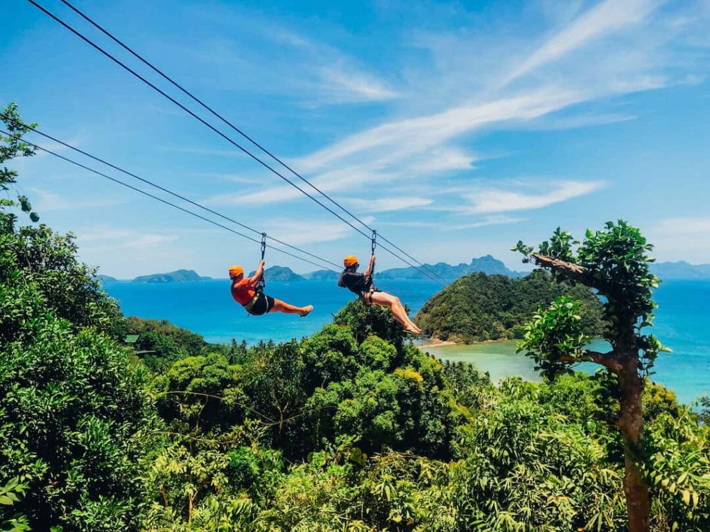 Two people zipling over the beach in the Philippines