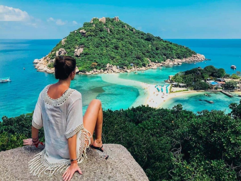 Woman sitting on a lookout point over the ocean in Thailand