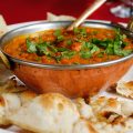 a dish of curry with naan